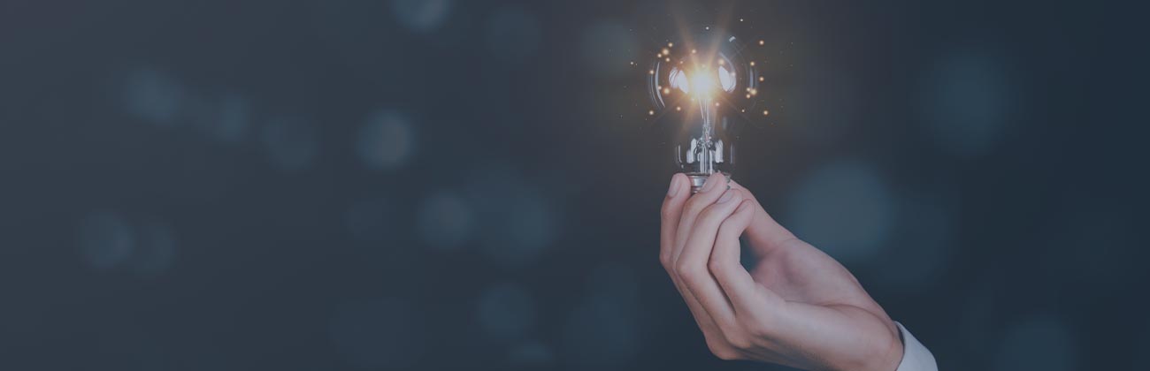 Main en costume tenant une ampoule